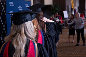 Students in graduation clothing walking in a line