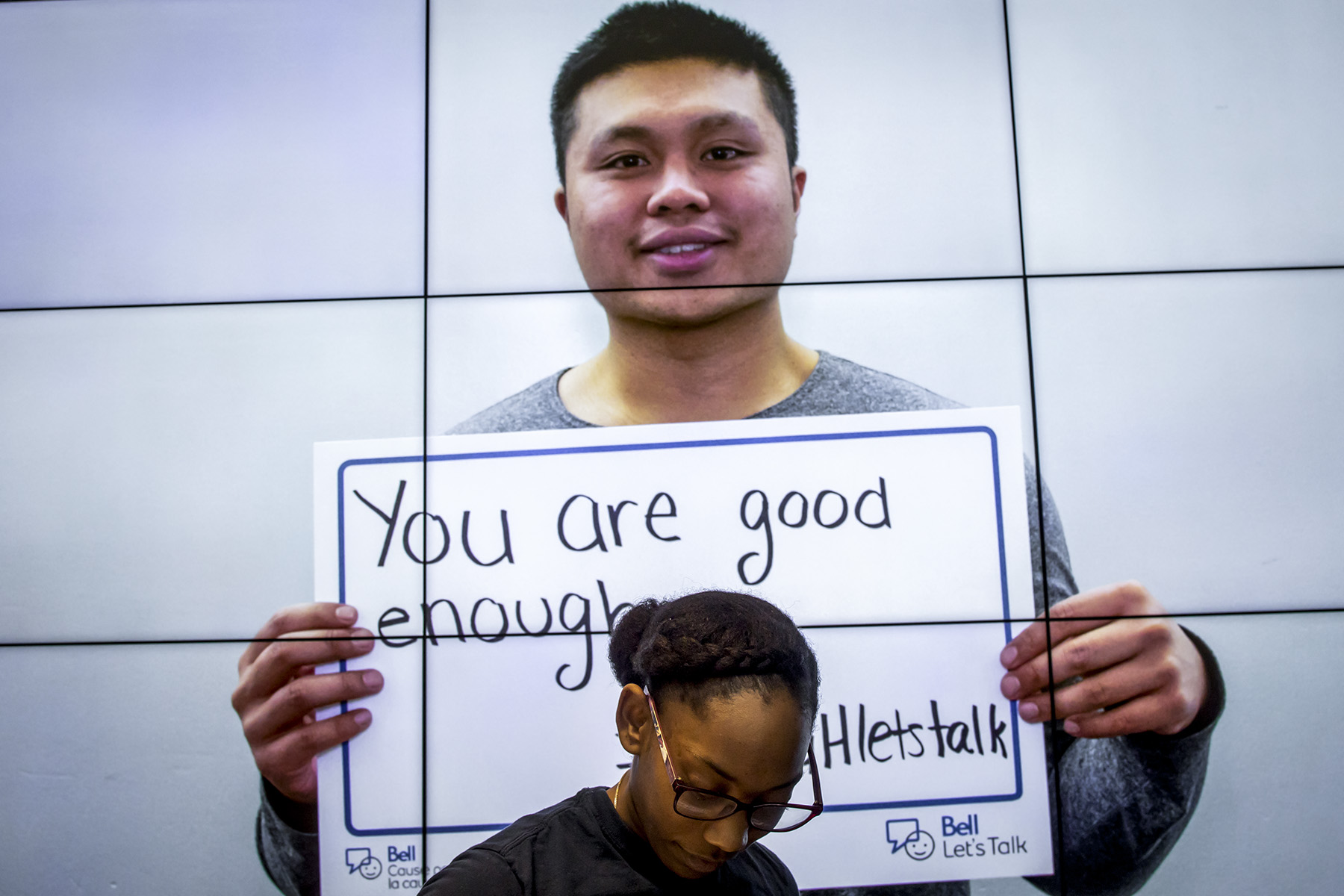 Student holding up a sign that reads: You are good enough