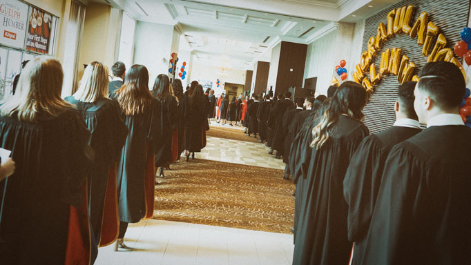 A line of graduates wait to enter the hall