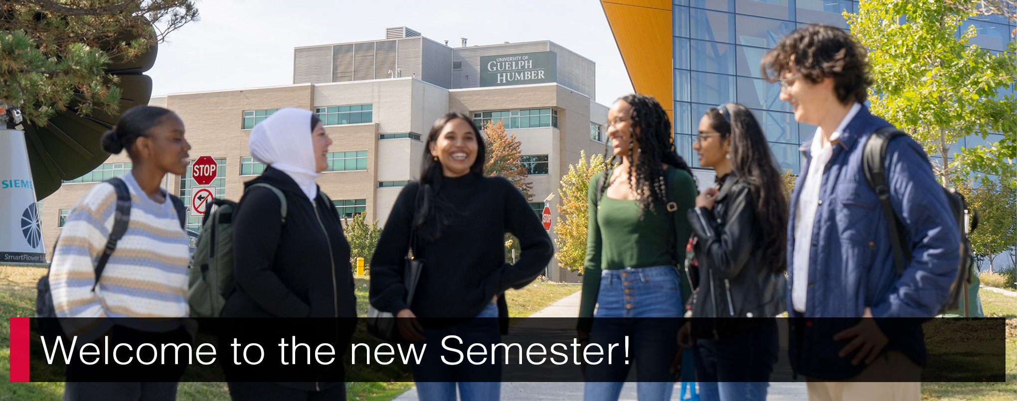 Six students in the foreground out of focus with the University of Guelph-Humber building in the background in focus