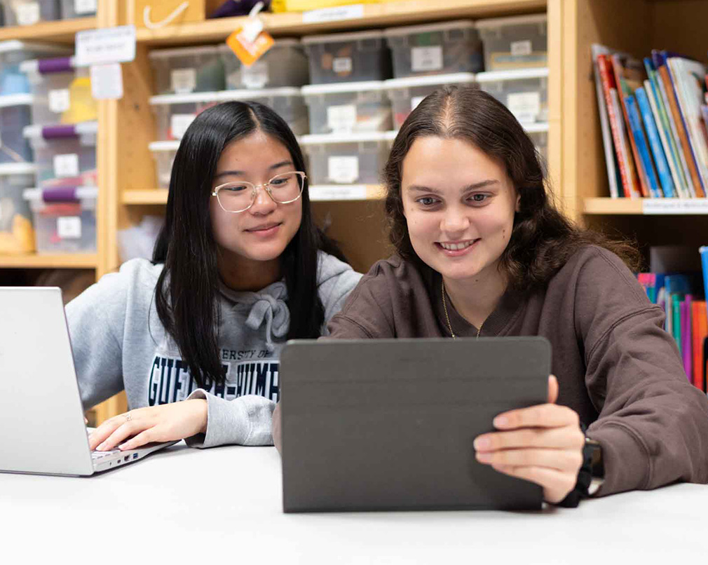 Two people looking at one tablet