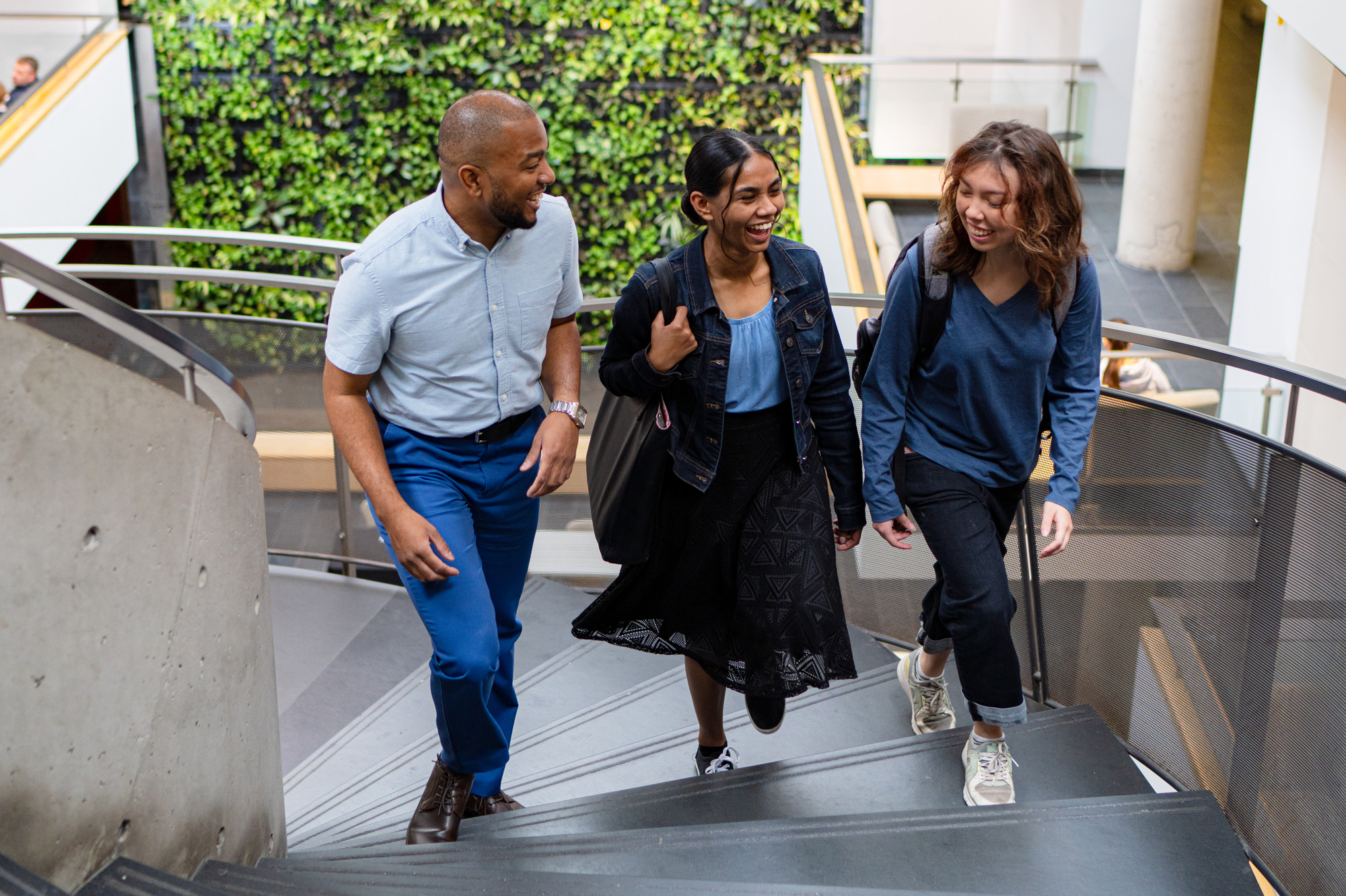 Three people walking up a flight of stairs