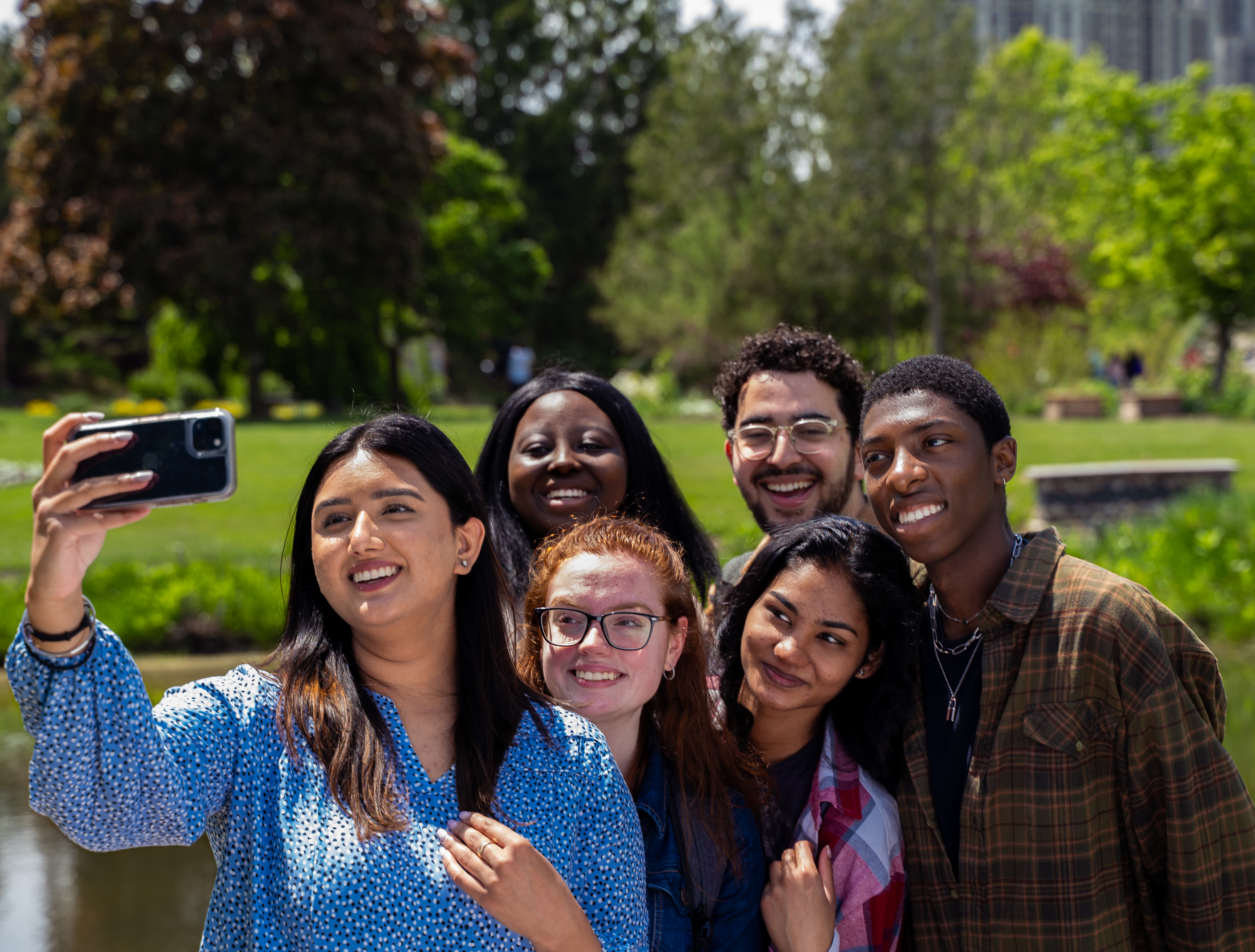 Group of 5 students taking a selfie photo in nature