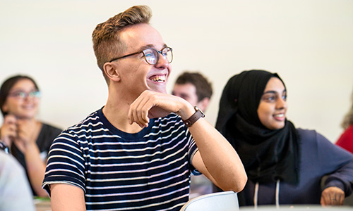 Psychology classroom Male student with hand under chin in classroom