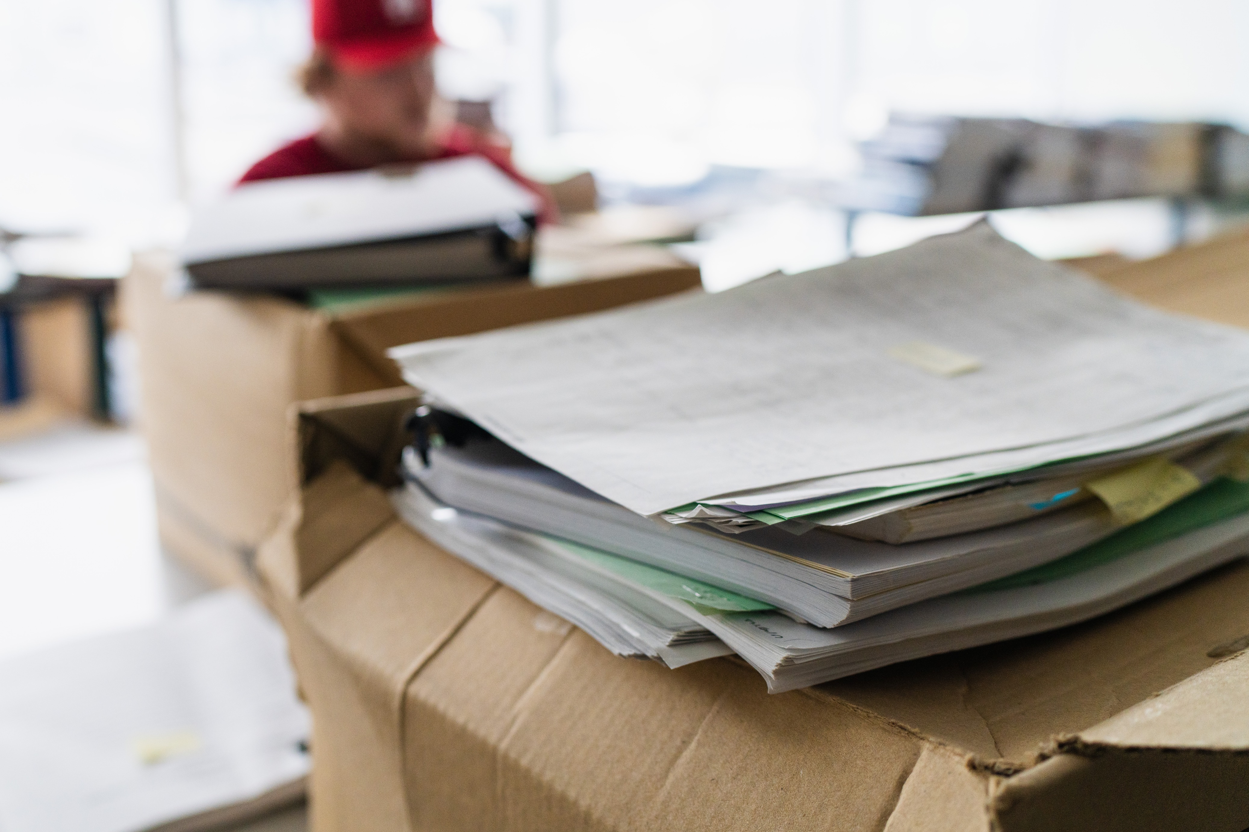 A box of documents with a student in the background