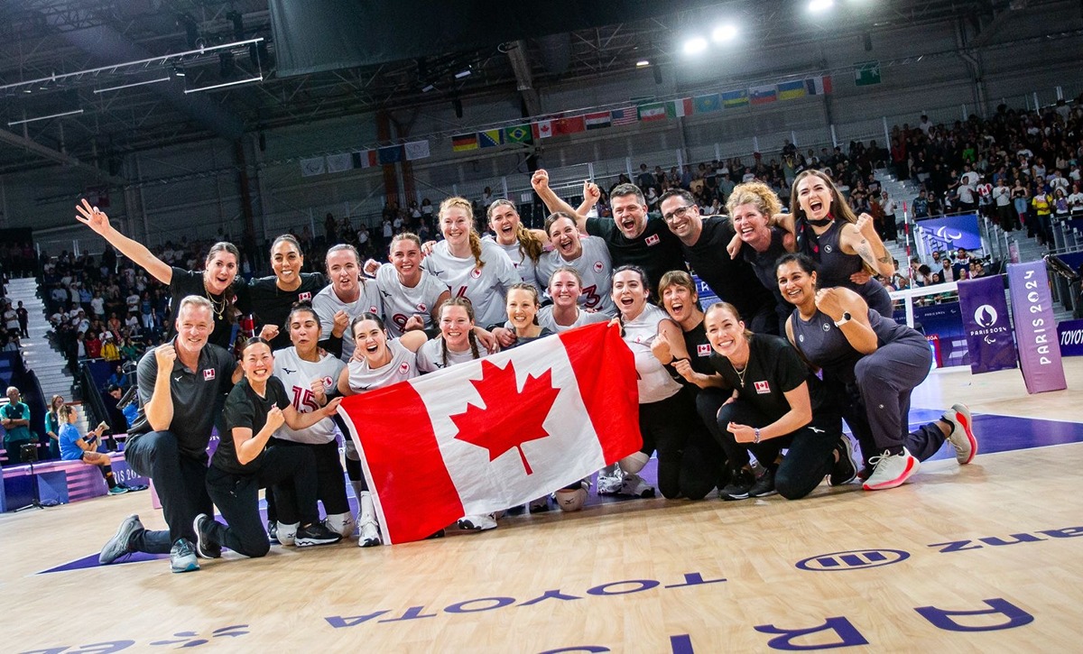 Team holding Canadian flag at Paris Paralympics